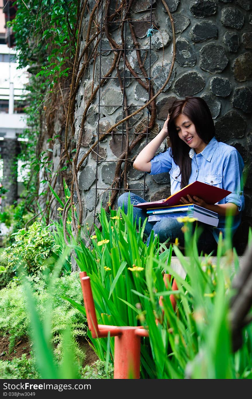 A female student is studying with her laptop in university's park. A female student is studying with her laptop in university's park