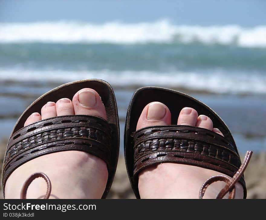 Sandals on the beach in vacation time. Holidays at the beach.