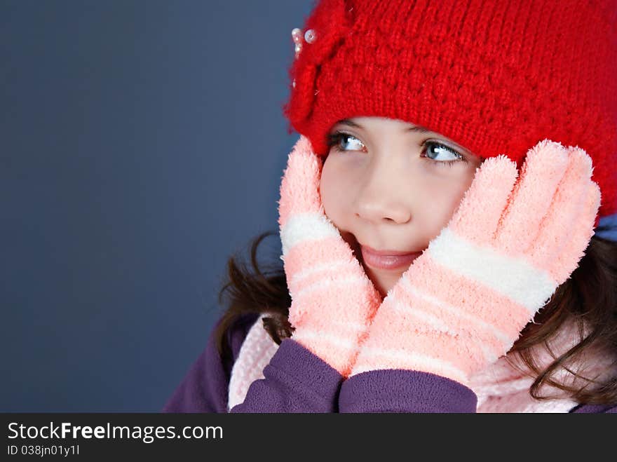 Girl in winter clothes on blue background