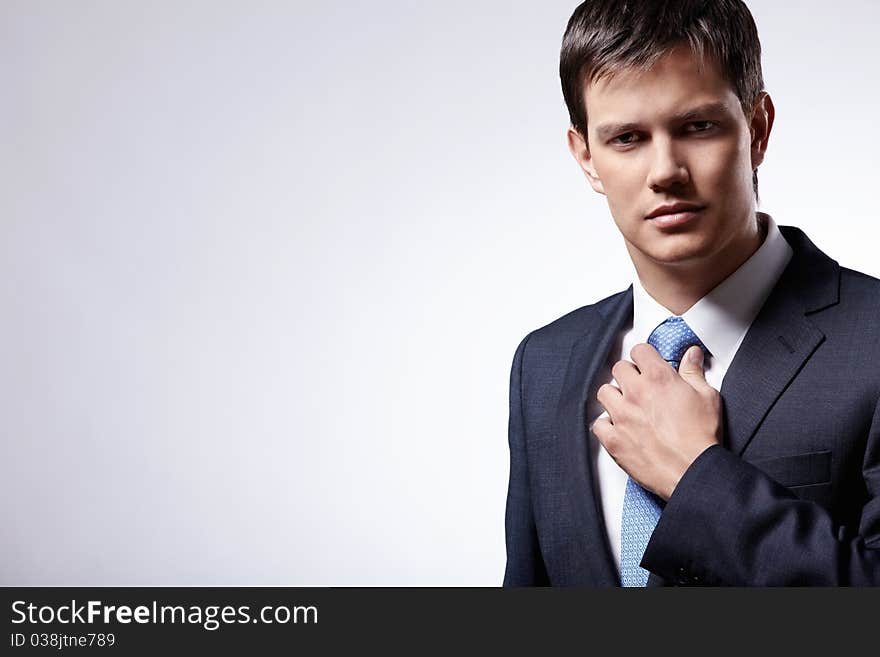 Attractive businessman in a business suit with a gray background