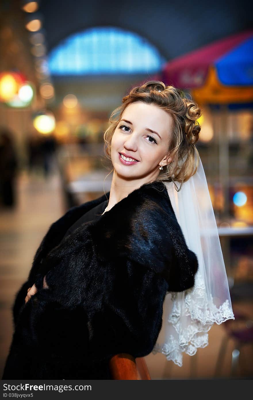 Beautiful bride in a fur coat in wedding day