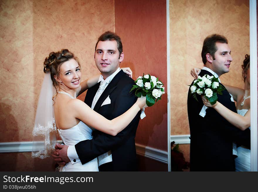 Happy bride and groom near mirror