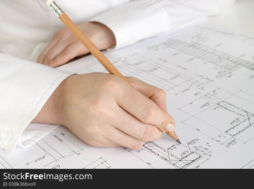 Hand with pencil drawing construction plan