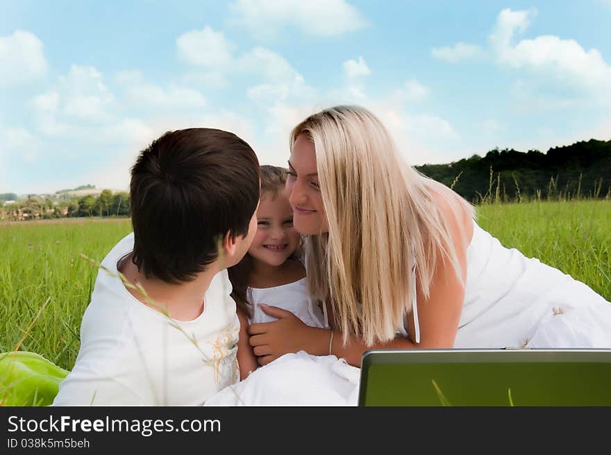 Happy family enjoy outdoors with computer