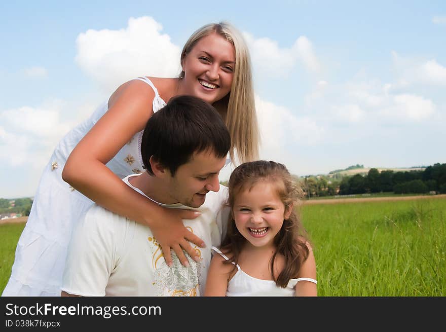 Happy young family enjoy on the meadow. Happy young family enjoy on the meadow