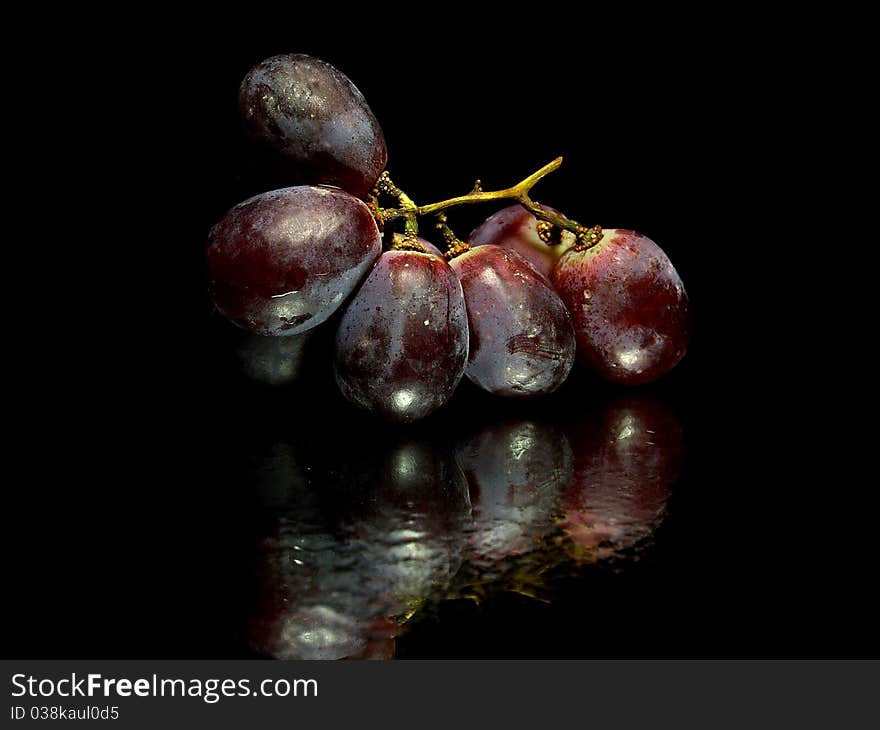 Red grape on a white background with water drops