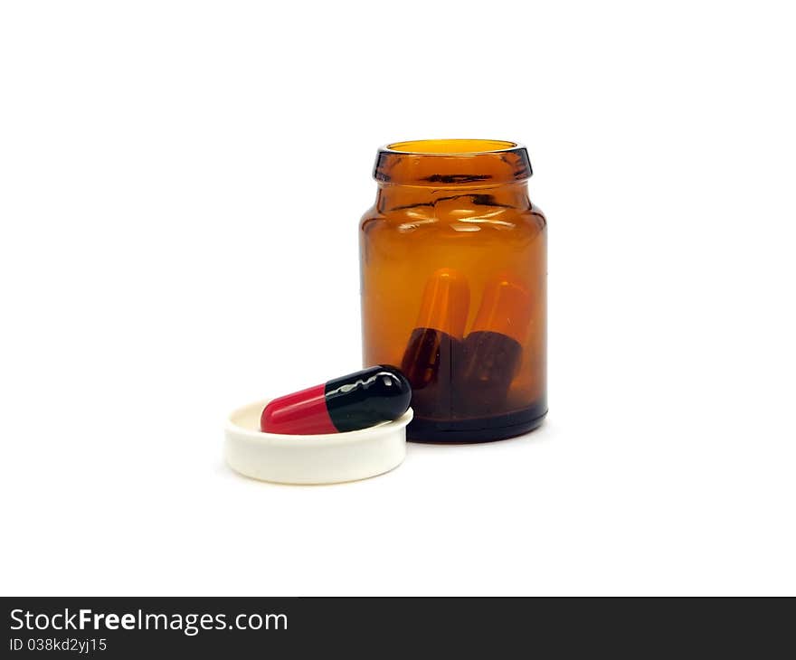 Pharmaceutical capsules in glass bottle on a white background