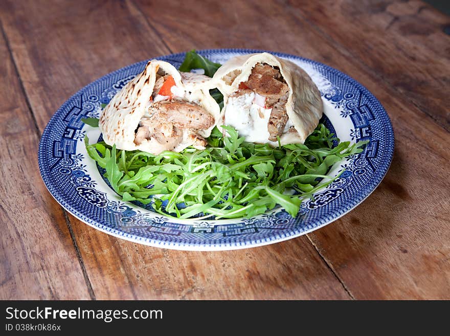 Pita bread sandwiches in blue plate on wooden table