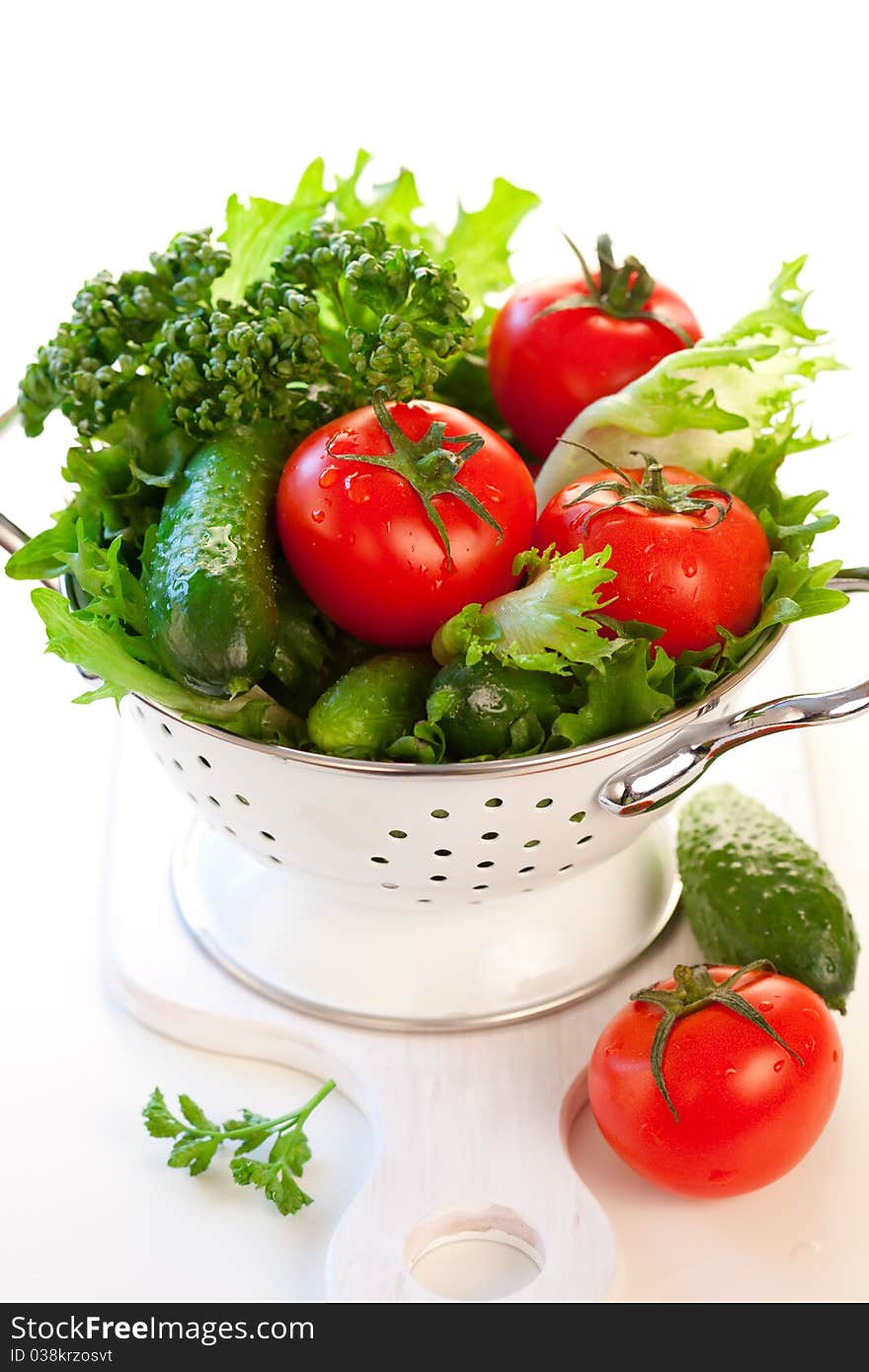 Tomatoes,cucumbers and lettuce leaves in a colander. Tomatoes,cucumbers and lettuce leaves in a colander