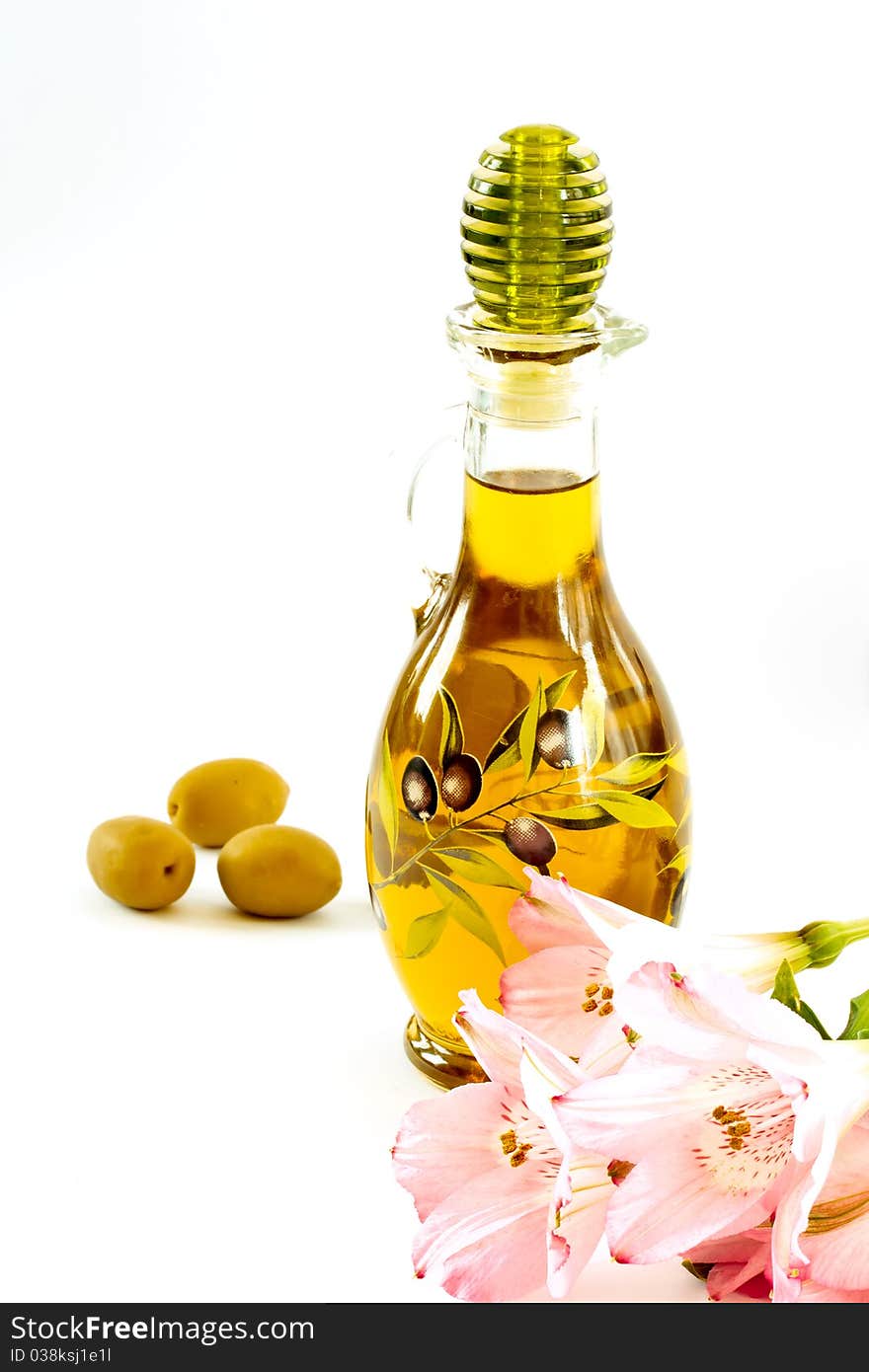 Fresh olive oil in a glass bottle on a white background