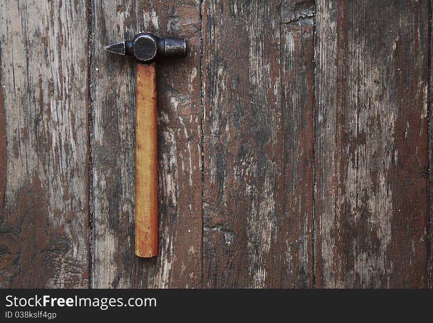 Old hammer against wooden wall. Old hammer against wooden wall