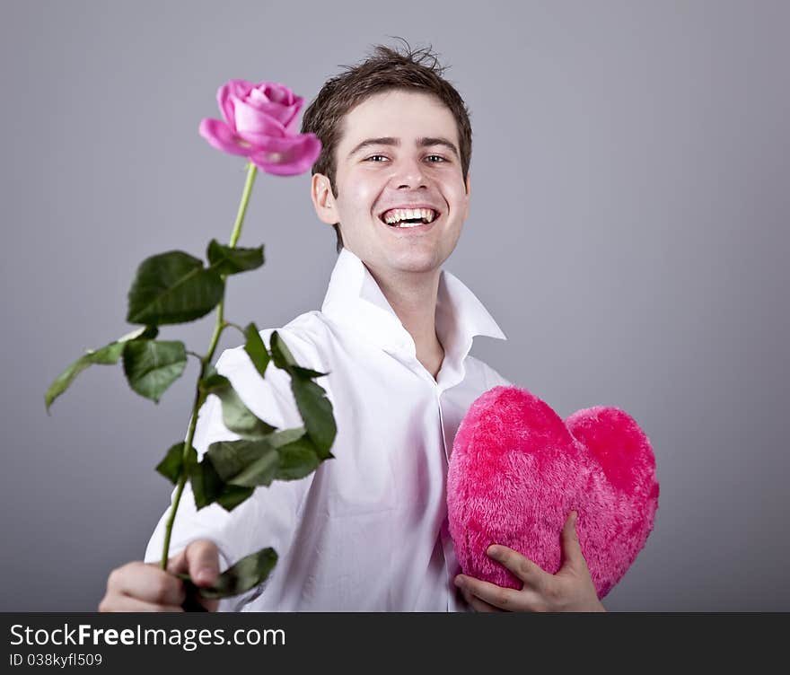 Funny men with rose and toy heart. Studio shot.