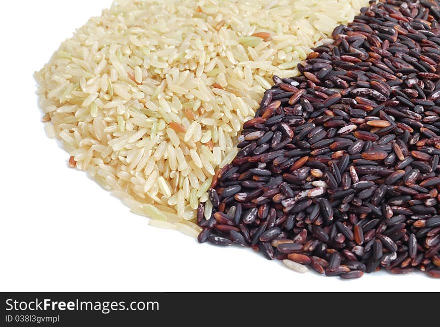 Isolated brown and black indica rice on white background, side view. Isolated brown and black indica rice on white background, side view