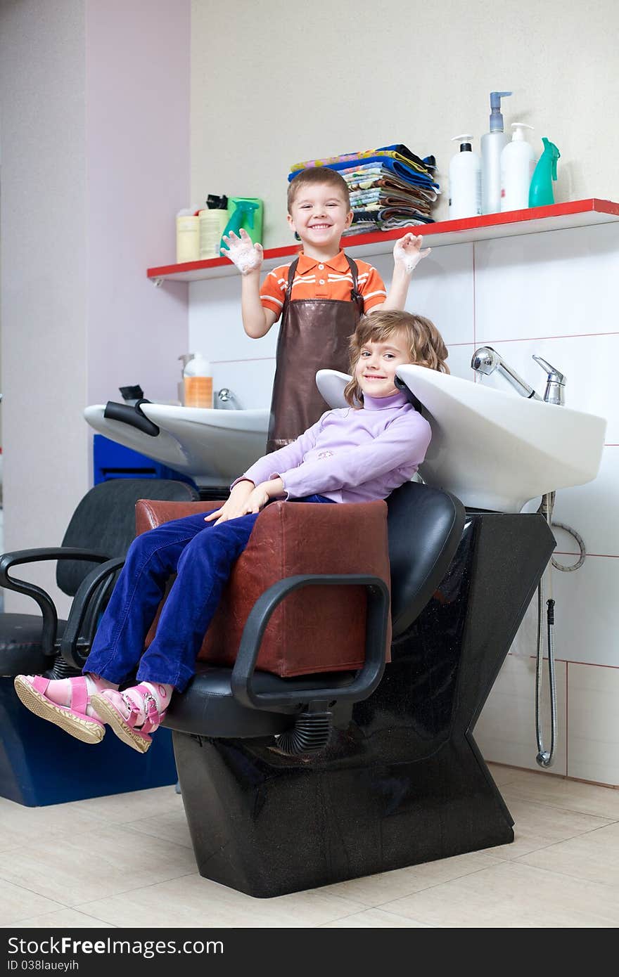 Little funny children play in the barbershop