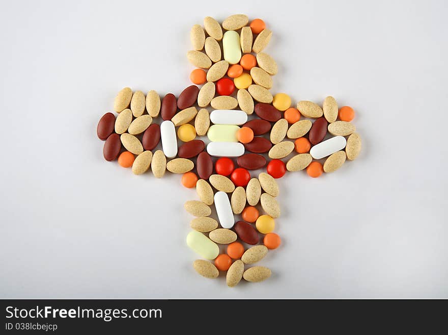 Pills forming a medical cross shape. Pills forming a medical cross shape