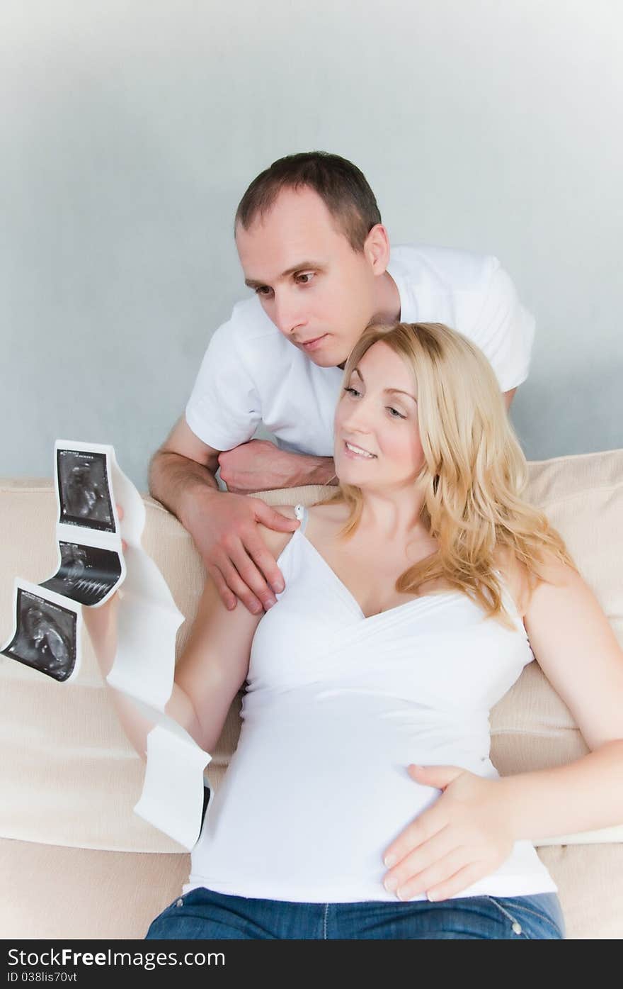 Young happy pregnant couple at home