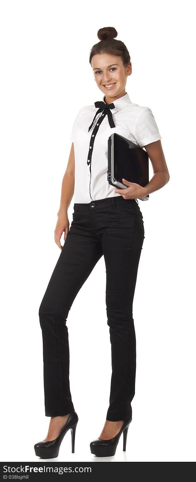 Girl in office attire stands and holds a laptop co