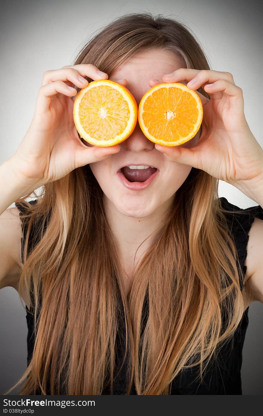 Girl using orange as eyes, with grey background