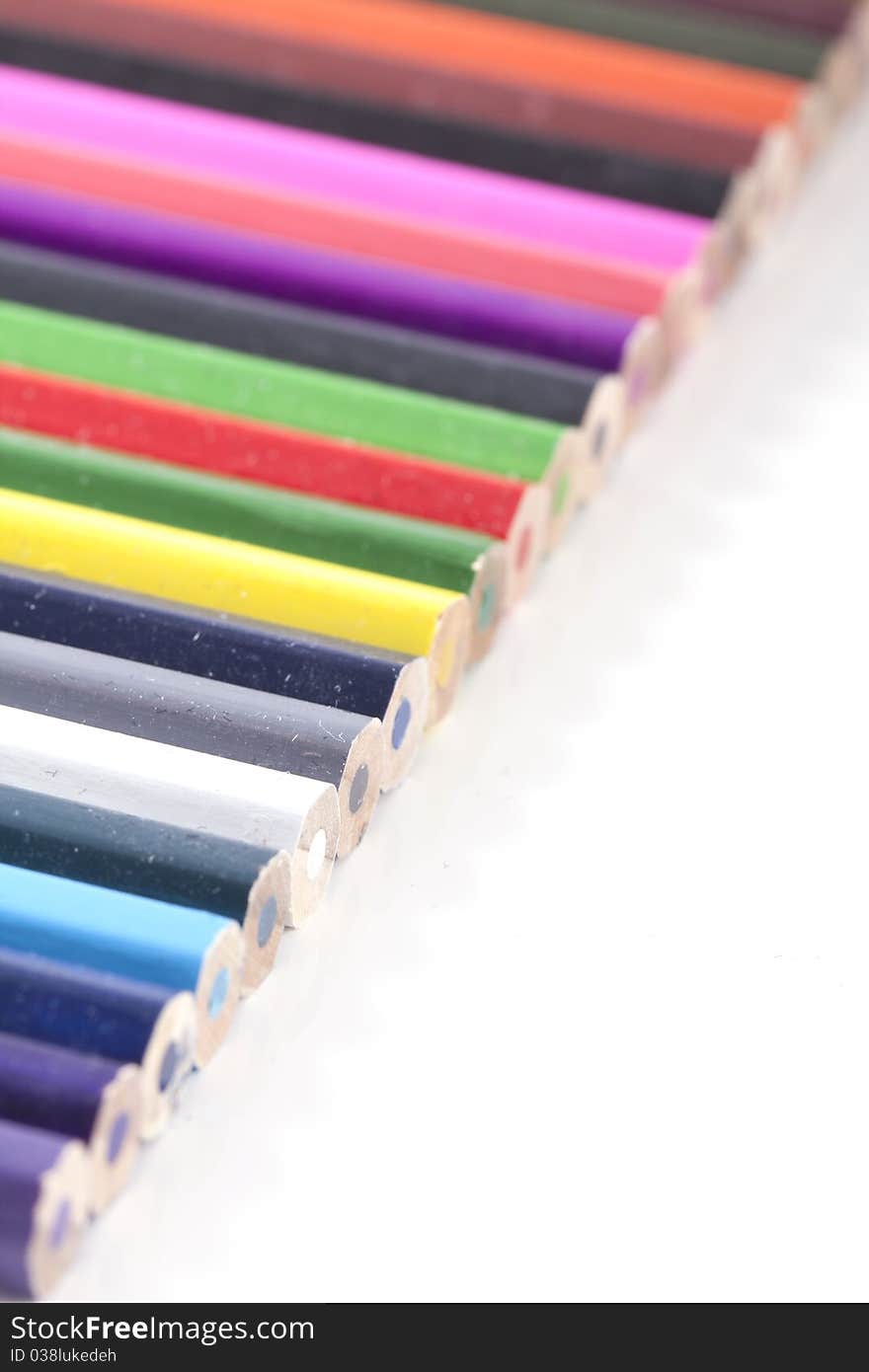 A standard diagonal row of colorfull colored pencils on white and a small depth of field