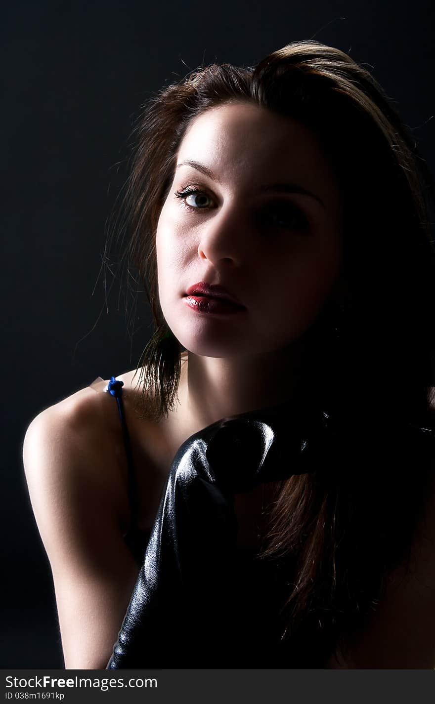 Portrait of pretty woman in blue dress and black gloves in studio on black background. Portrait of pretty woman in blue dress and black gloves in studio on black background