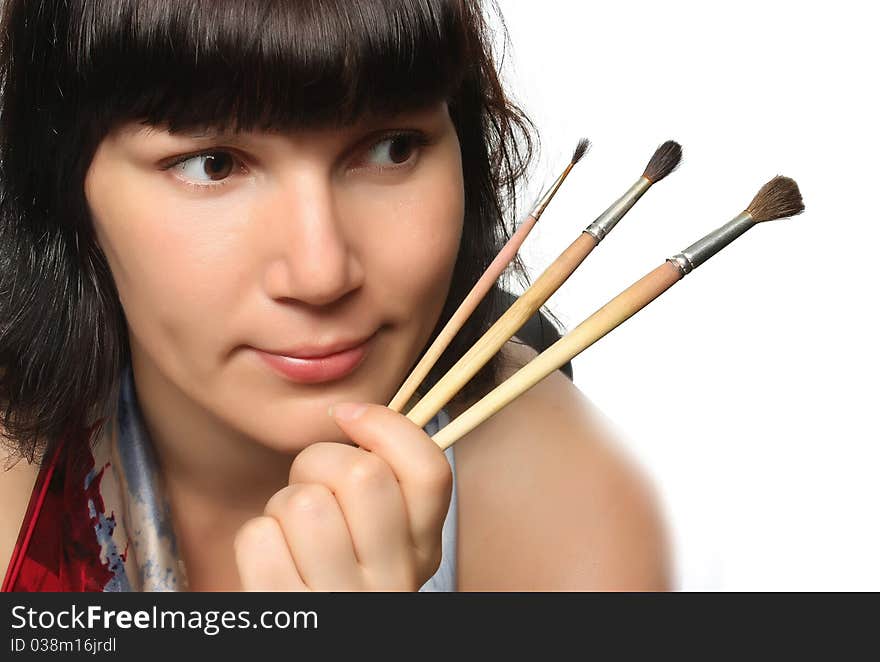 Beautiful girl holding brushes.