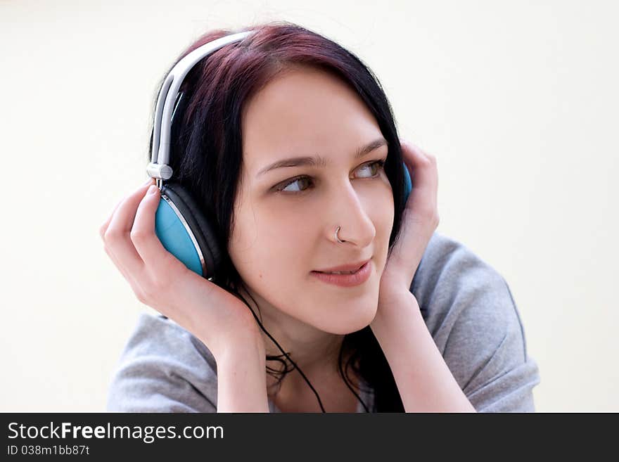 Caucasian dark haired woman with earphones on the chair