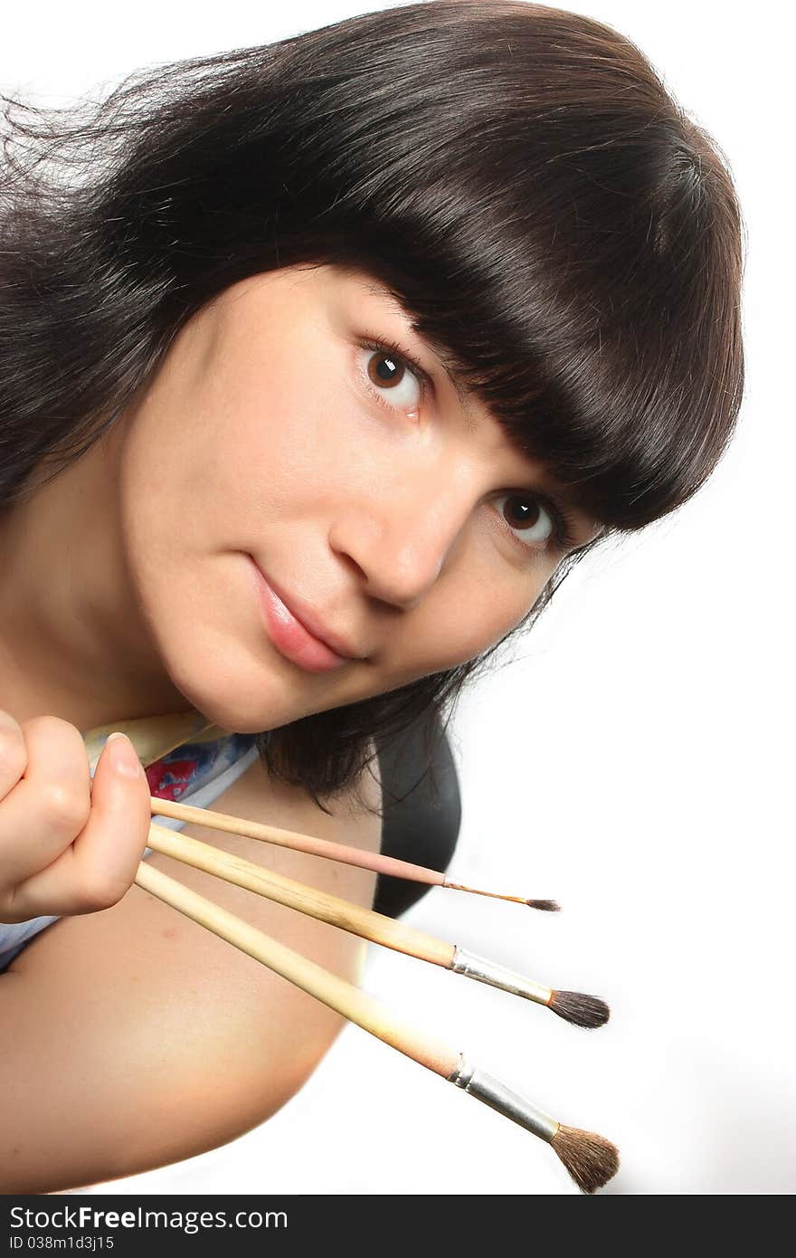 Beautiful girl holding brushes.