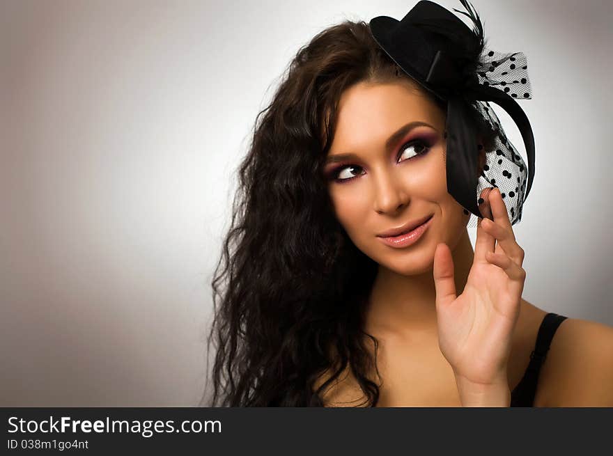 Portrait of young beautiful woman in little hat.