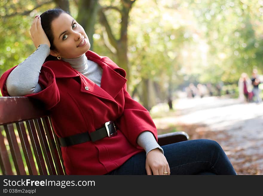 Woman sitting in a park on a wooden bench