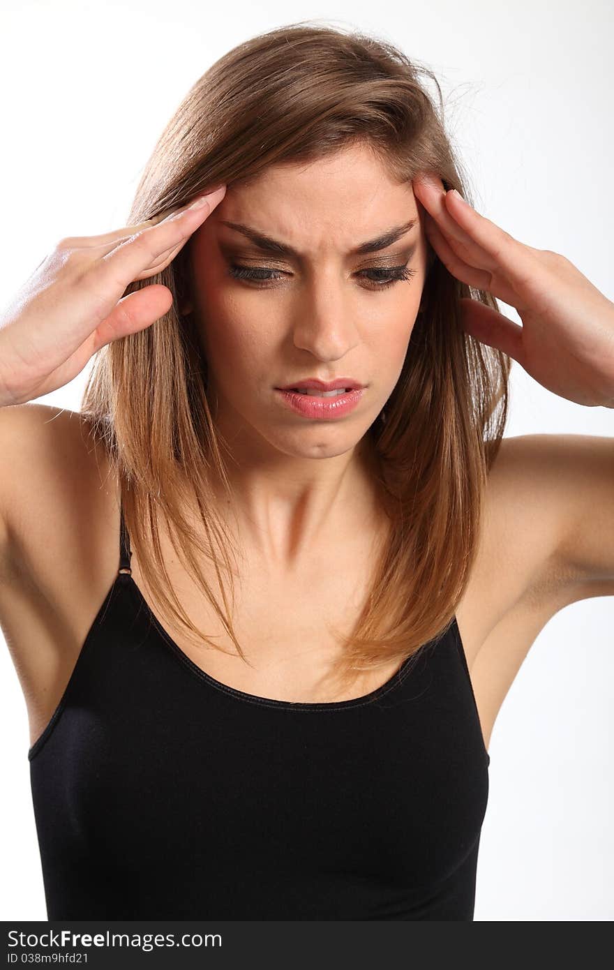 Headshot of beautiful young woman, hands raised to forehead and face showing anguish of a headache. Headshot of beautiful young woman, hands raised to forehead and face showing anguish of a headache.