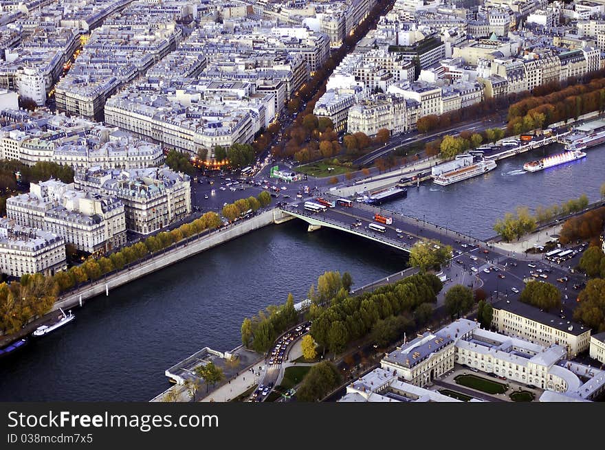 A bird's-eye view of a bridge across the Seine river with the streets and buildings on its both sides.