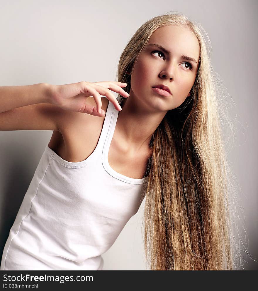 Portrait of attractive beautiful young girl posing on grey background. Portrait of attractive beautiful young girl posing on grey background