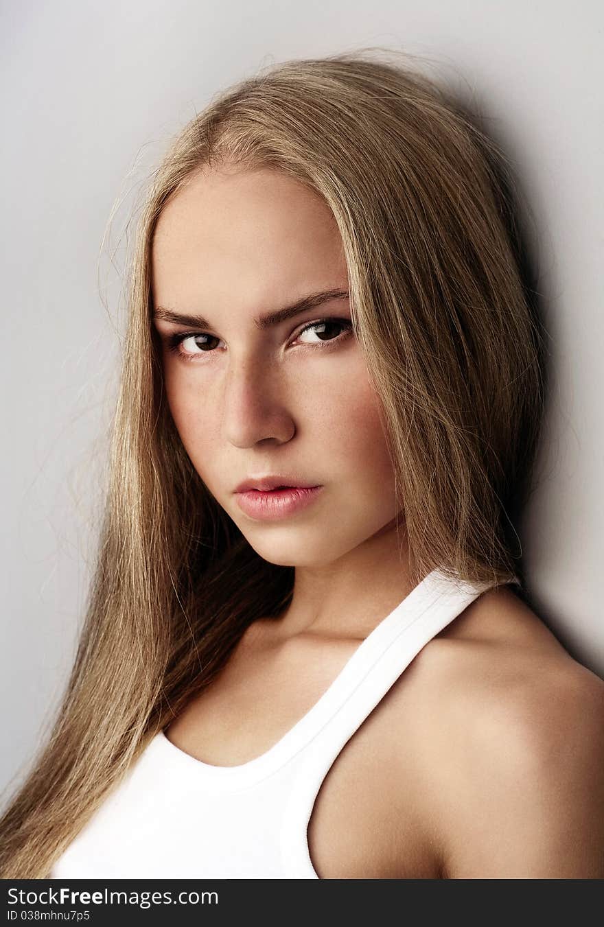 Portrait of attractive beautiful young girl posing on grey background. Portrait of attractive beautiful young girl posing on grey background