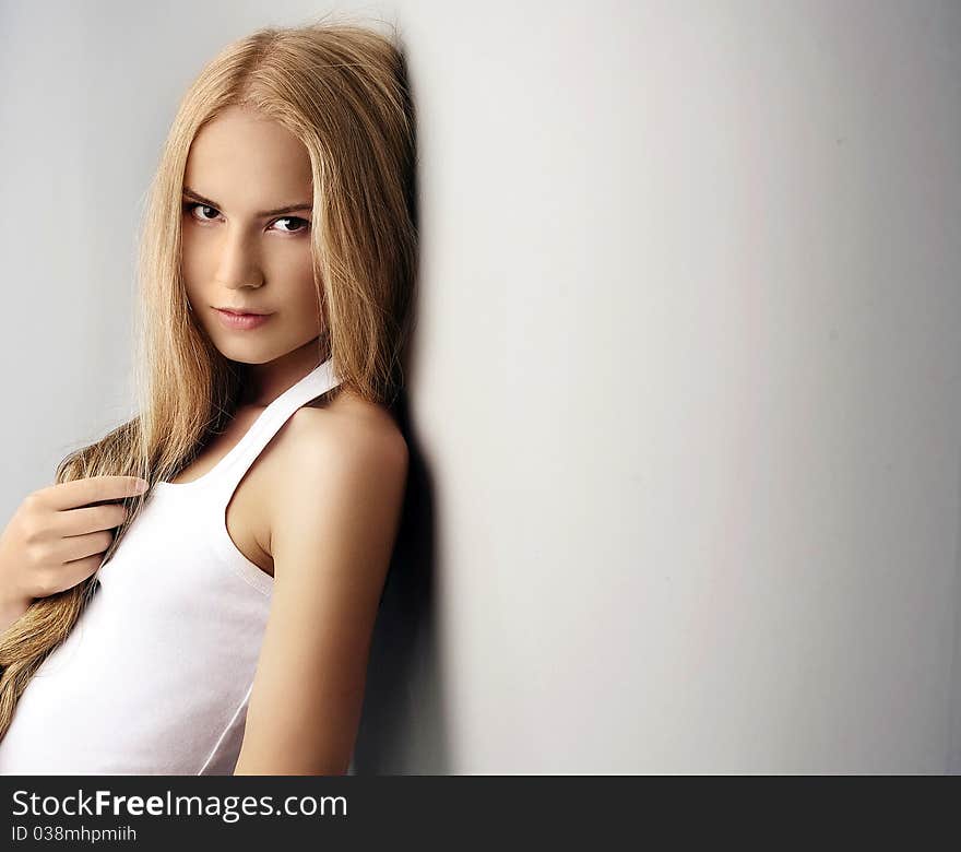 Portrait of attractive beautiful young girl posing on grey background. Portrait of attractive beautiful young girl posing on grey background