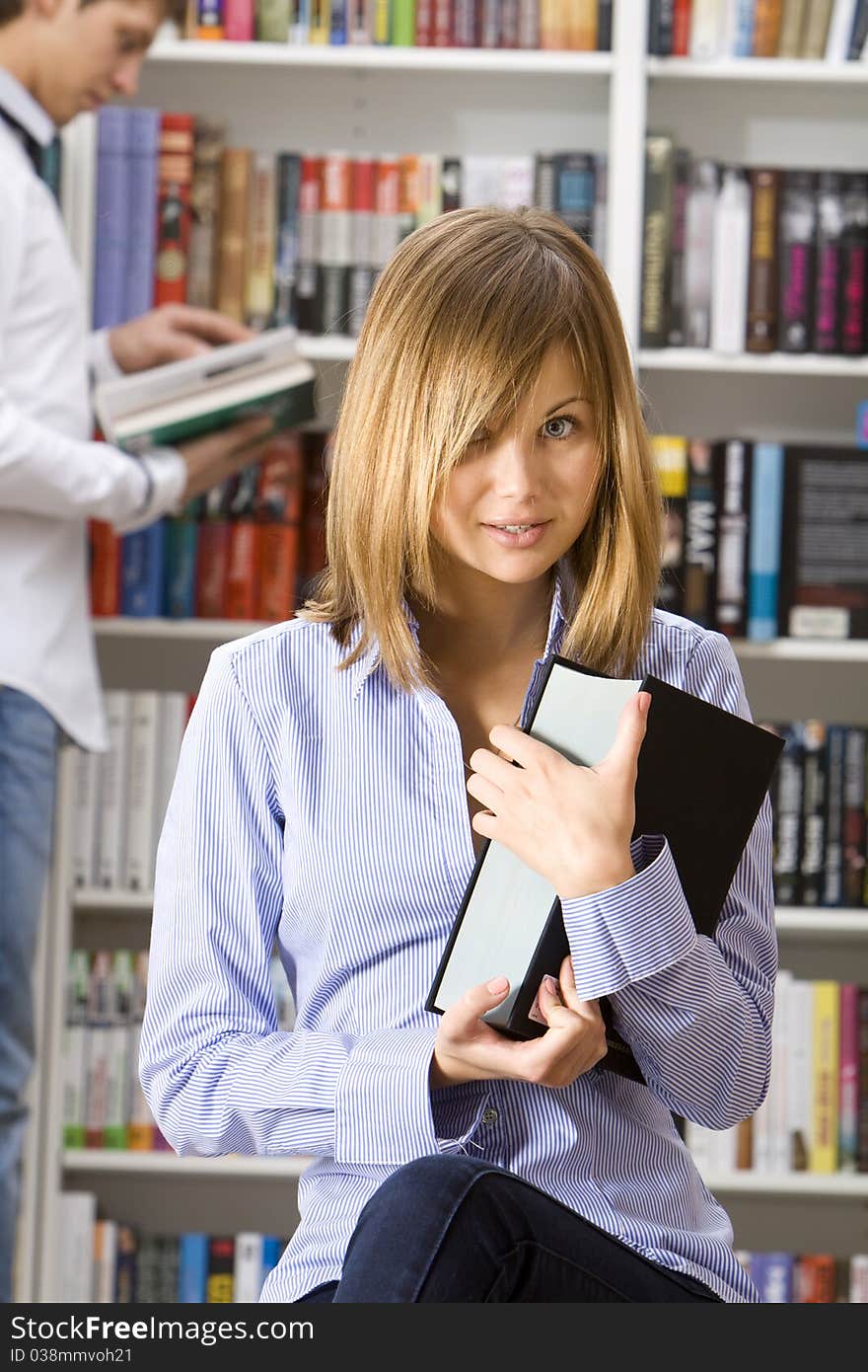 Young woman in the library with the book