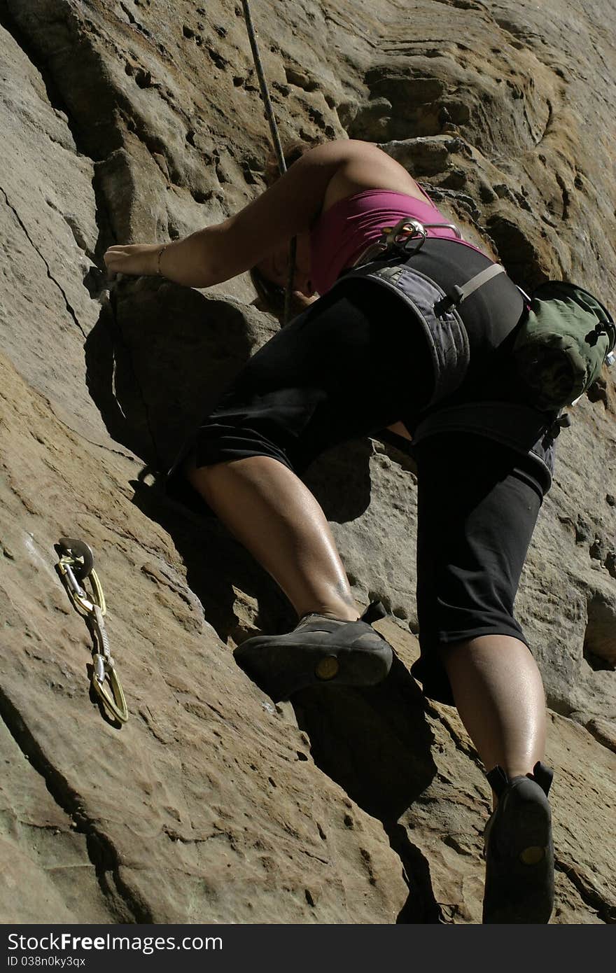 A healthy, young woman climbing outdoors. A healthy, young woman climbing outdoors.