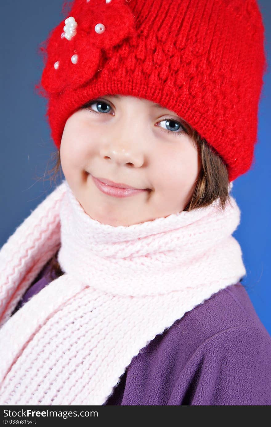 Girl in winter clothes on blue background