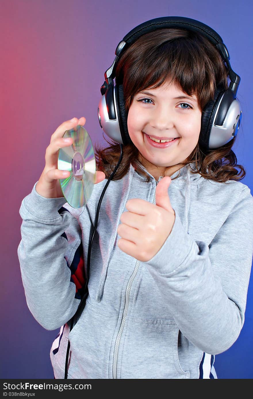 Cute little girl with earphones and cd isolated on blue