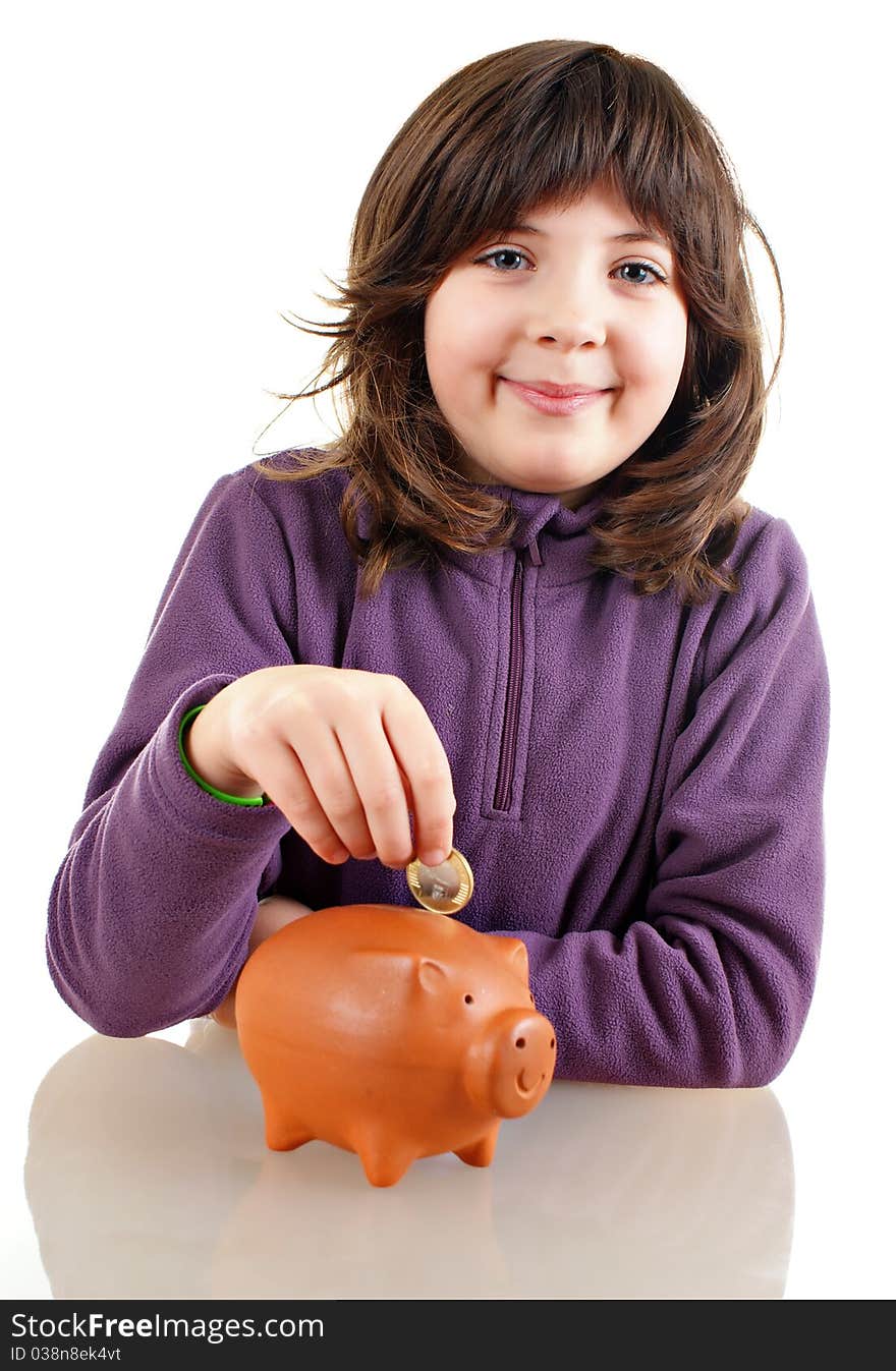 Girl saving money in a piggy bank isolated