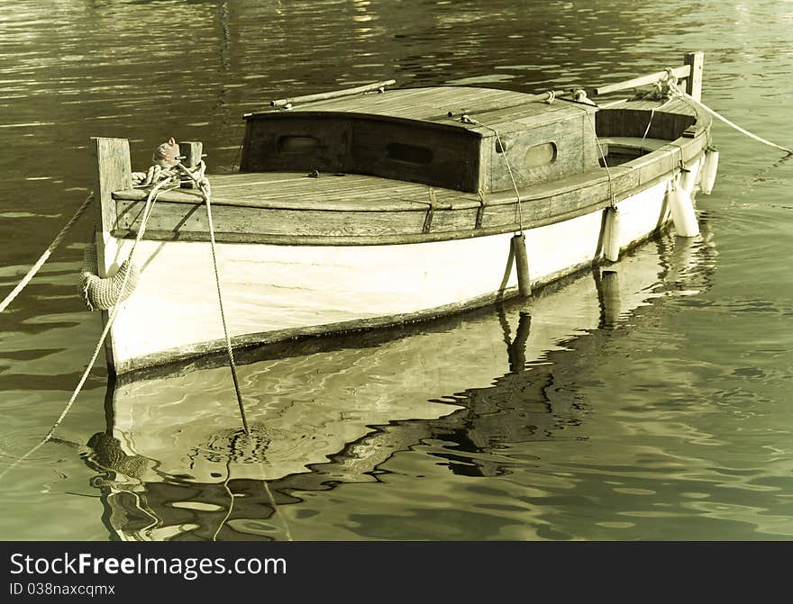 Very old wooden boat, hand made, fishermans boat in harbour, sepia filter, antique, made by wood