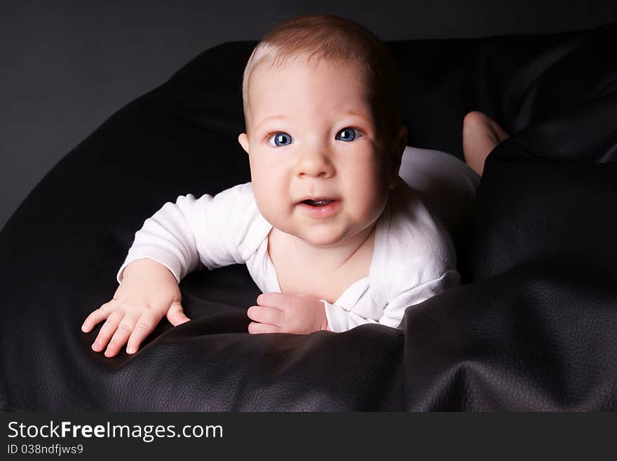 Portrait of smiling blue-eyed baby boy, studio shot