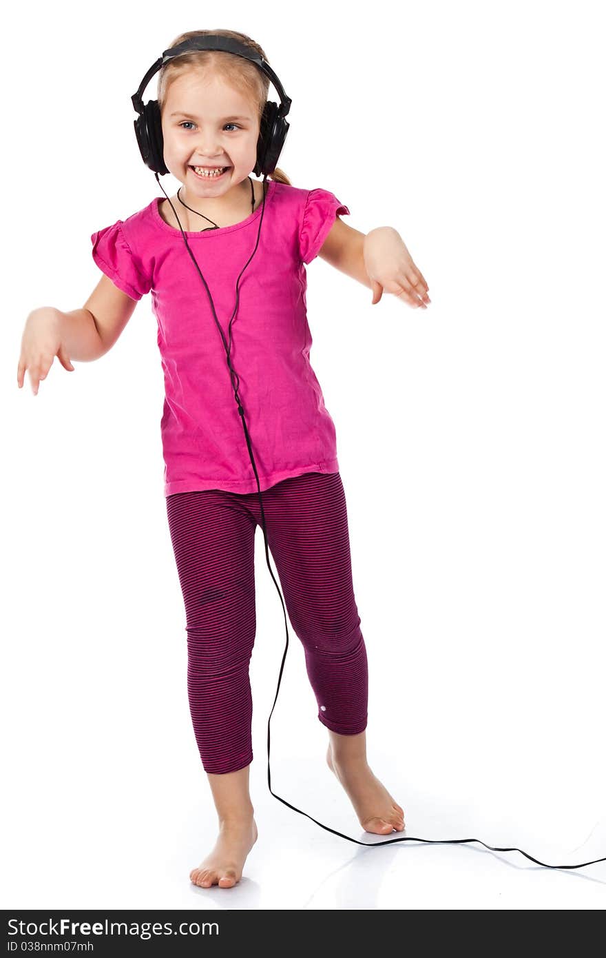 Beautiful girl in headphones dancing to the music isolated on white