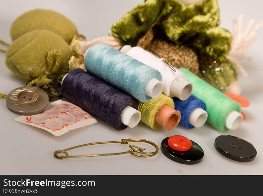 Thread sewing and needles with buttons on a white background