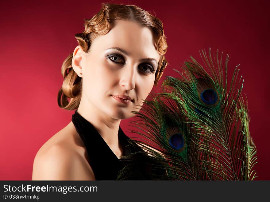 Portrait of elegant woman holding pavlin feather