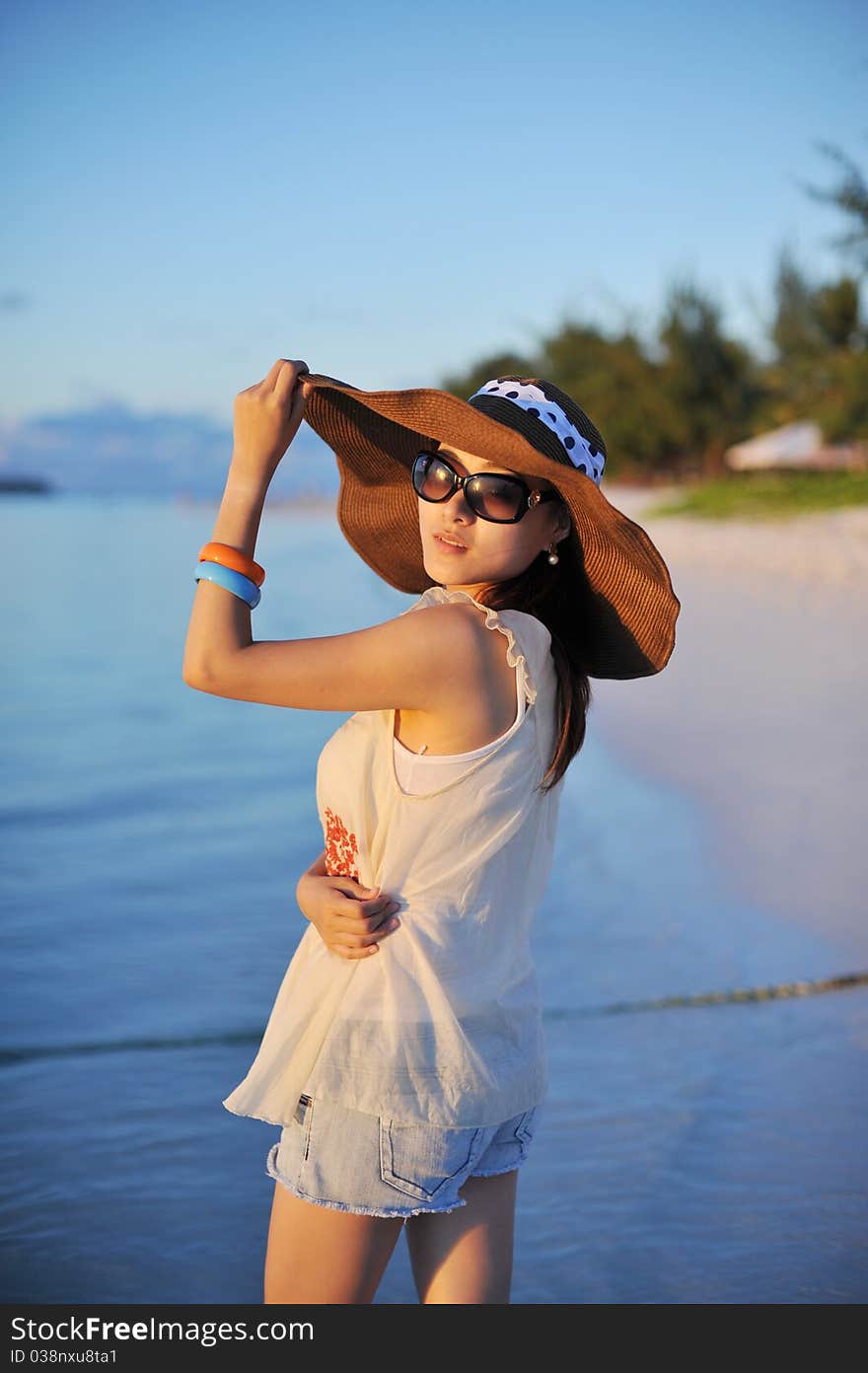 Girl in sunset with a straw hat