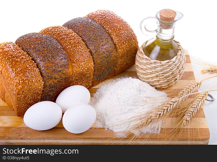 Fresh bread,  eggs,  flour  and  oil  on  wood  board