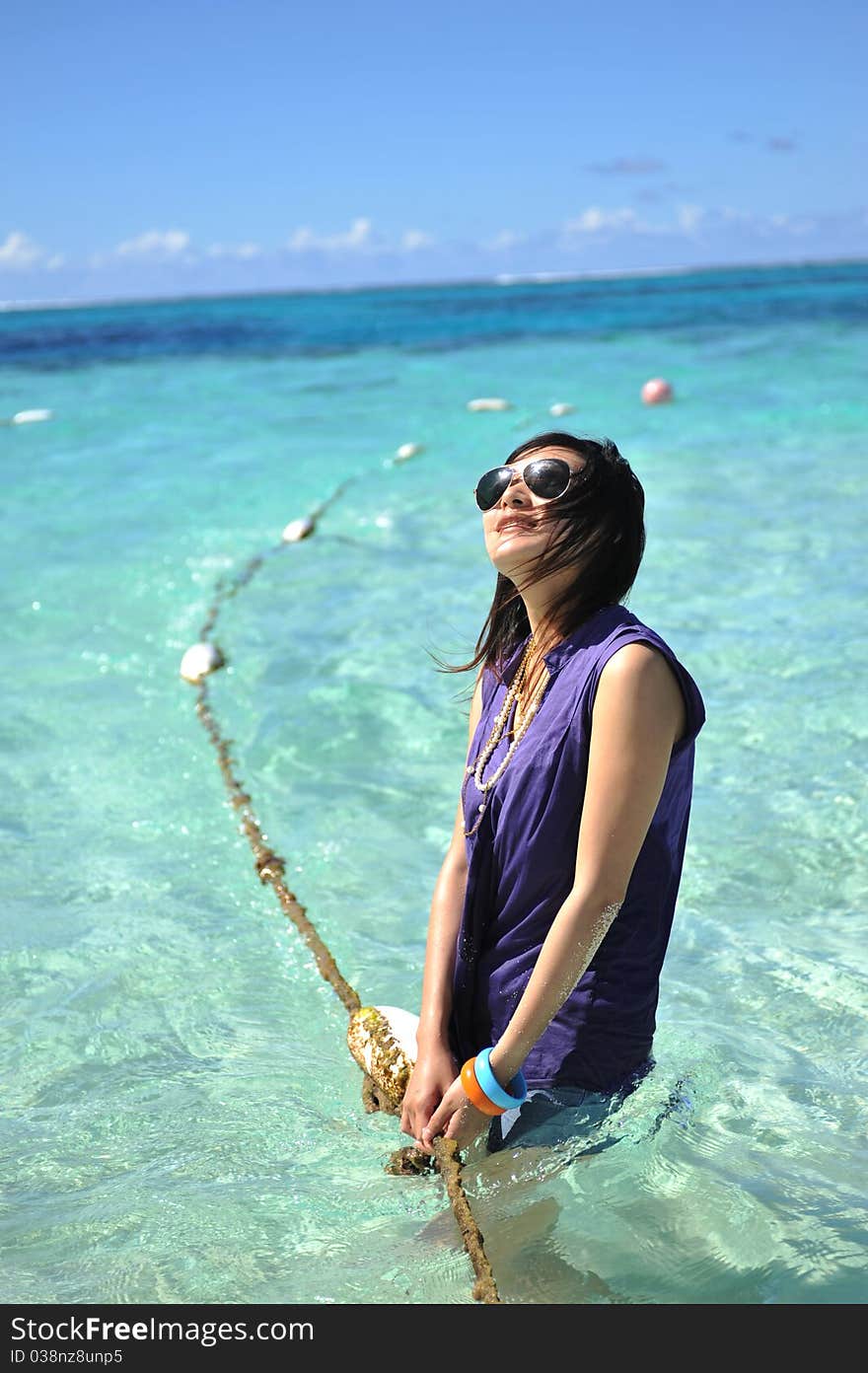 Asian Girl on the beach of Saipan Island,playing in the sea water with the strings. Asian Girl on the beach of Saipan Island,playing in the sea water with the strings.