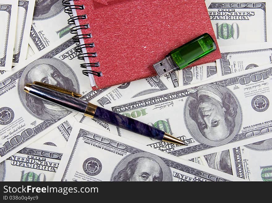 Dollars, notebook and pen