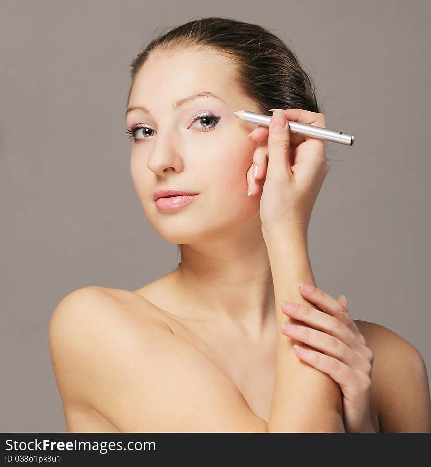 Young girl with eyeliner in hand