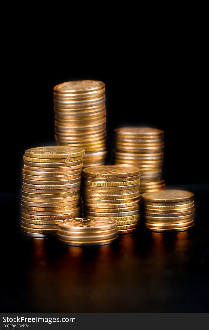 Piles of gold coins on a black background